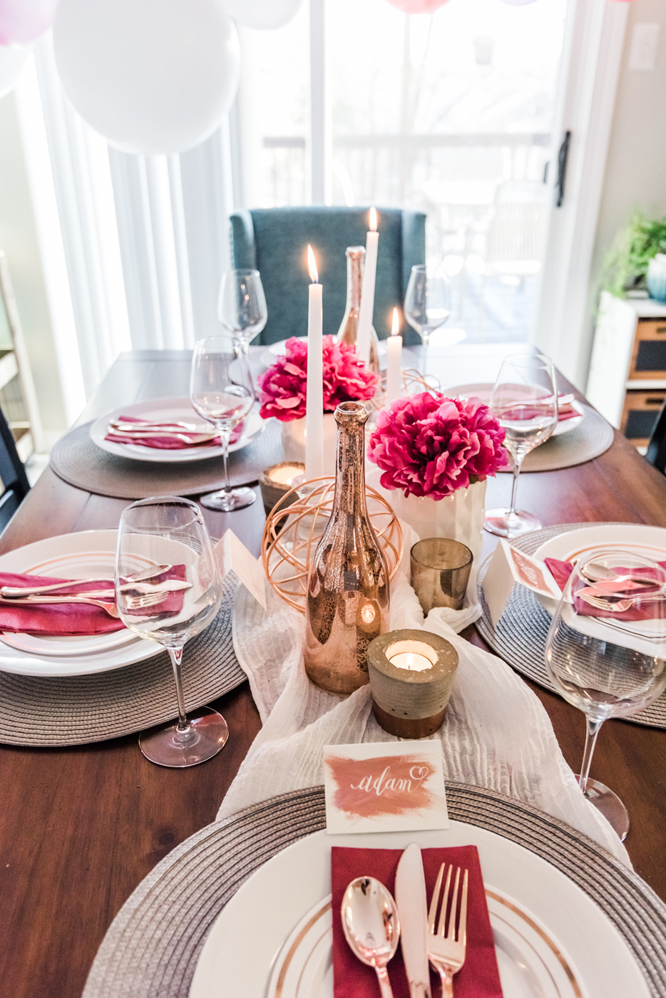 Valentine's day dinner table setting with roses and balloons