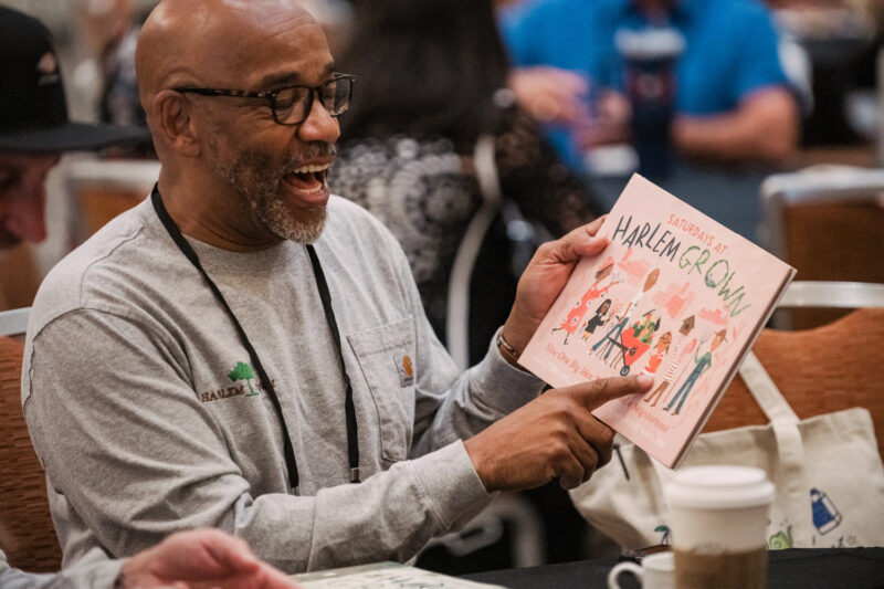conference guests points to a book