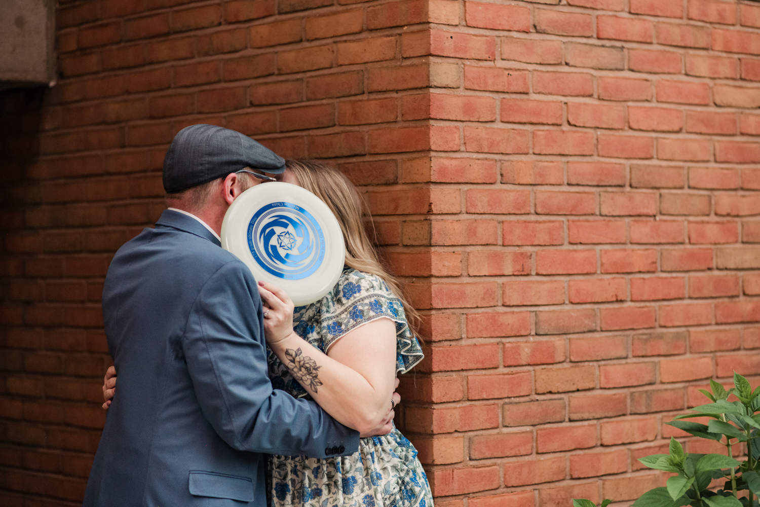 couple embracing behind frisbee outside math building umbc campus