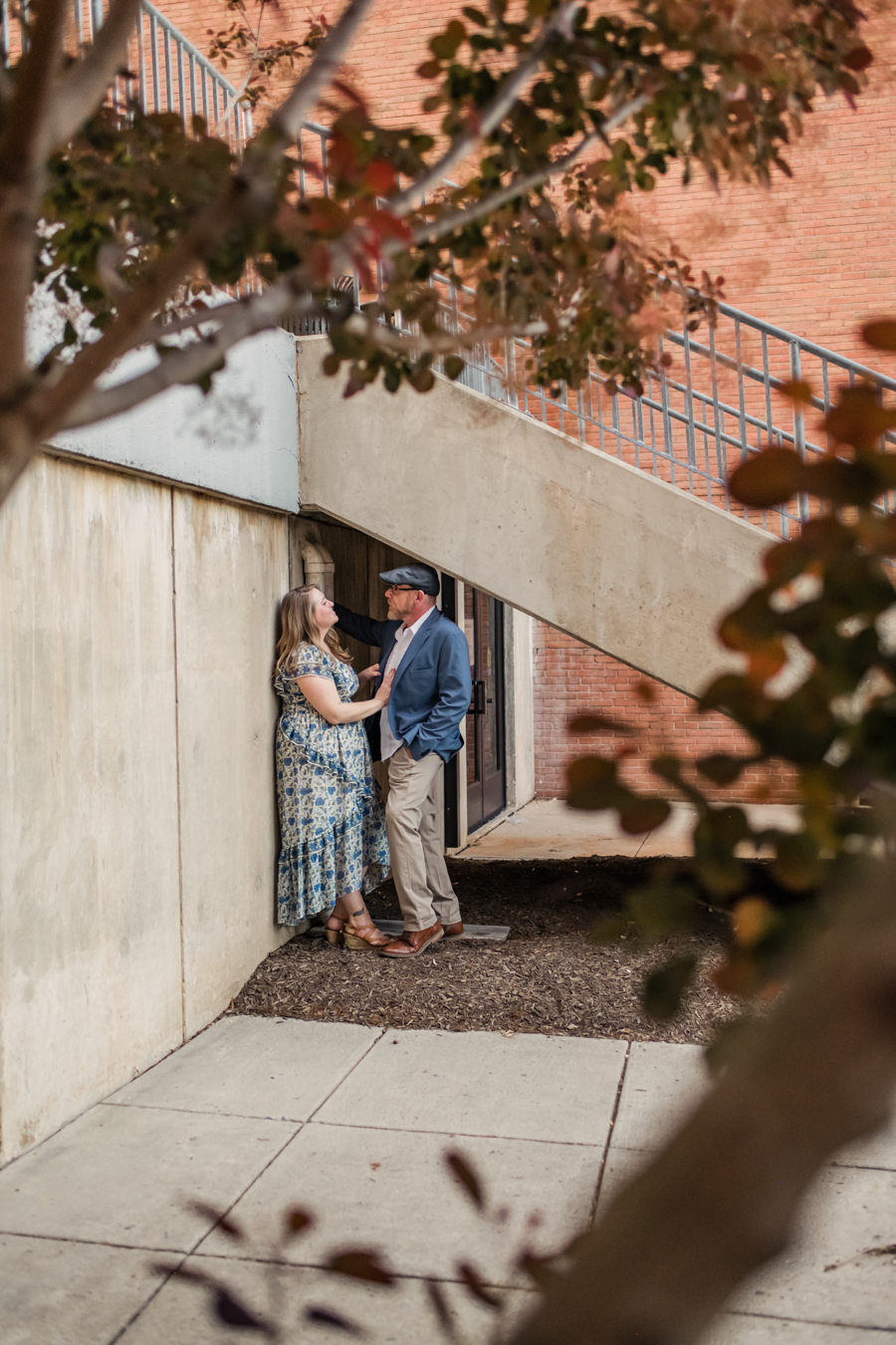 couple under staircase at umbc framed by tree leaves