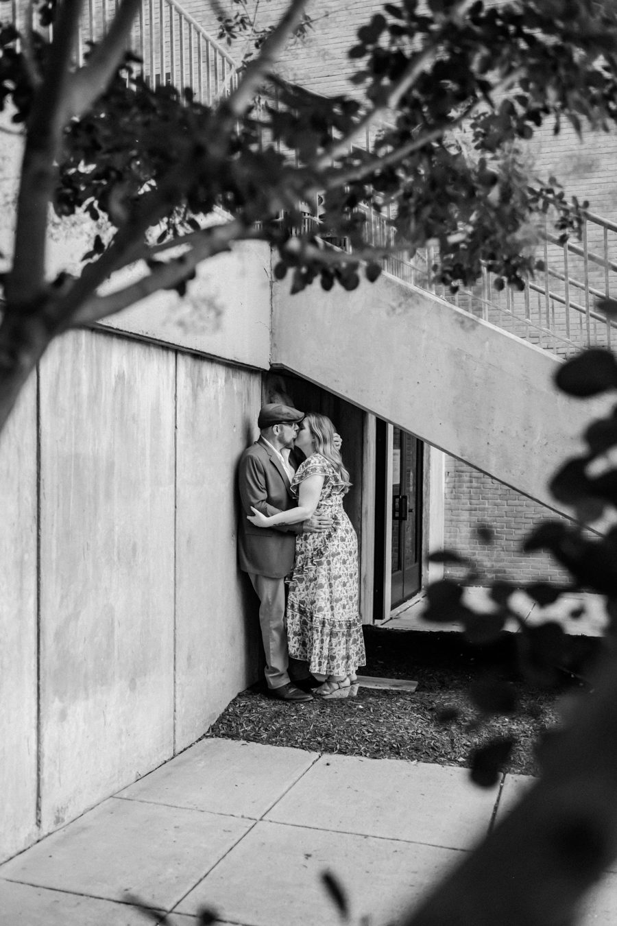 black and white image of couple embracing under staircase at umbc