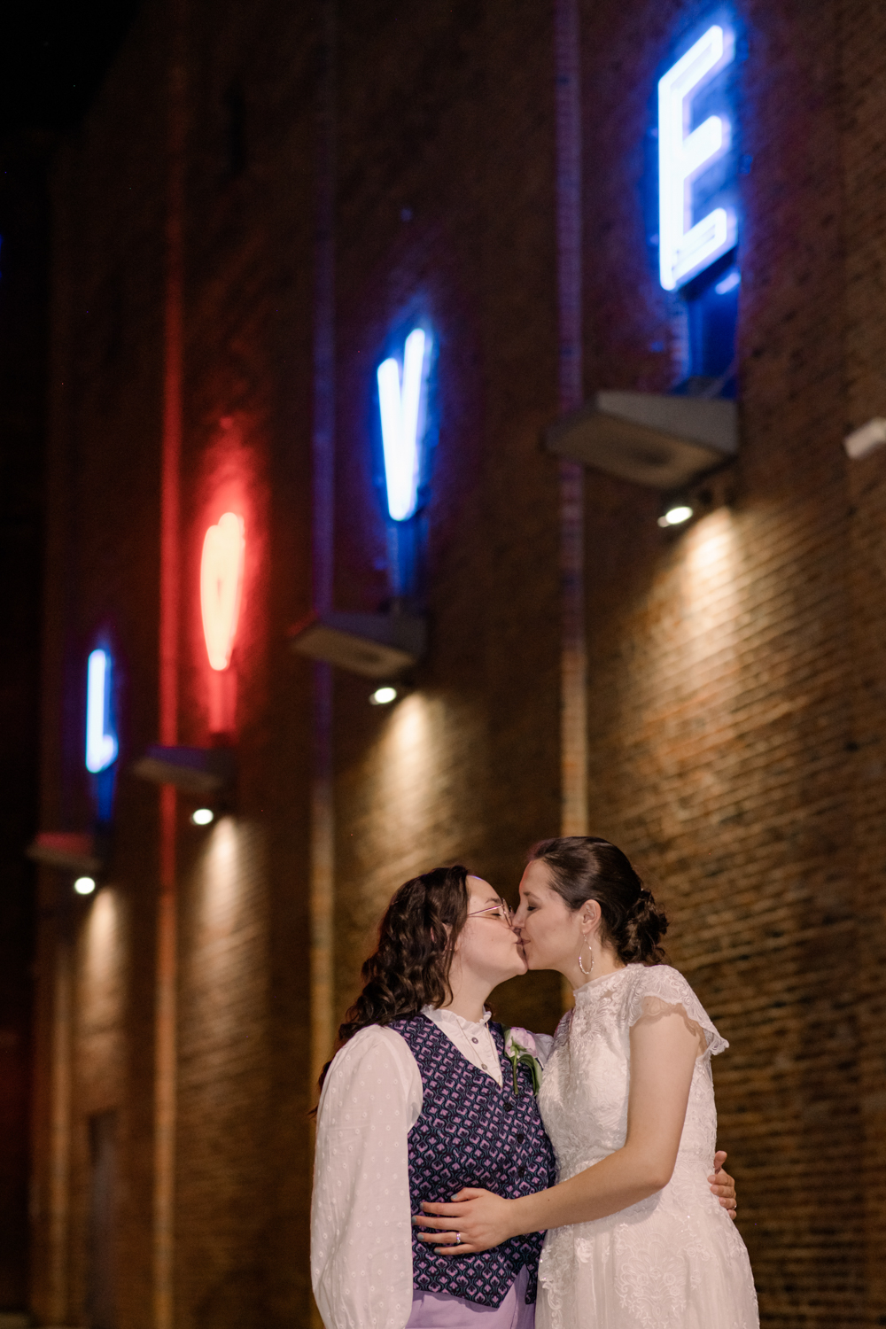 wedding couple kiss in front of AVAM LOVE sign