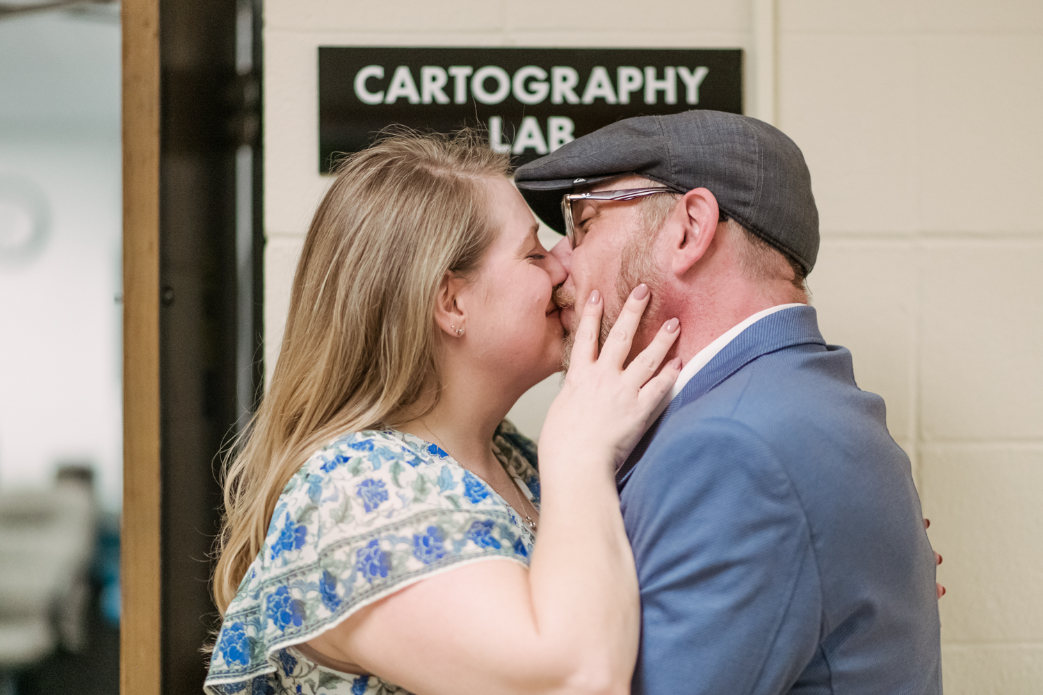 couple kisses in front of cartography lab sign