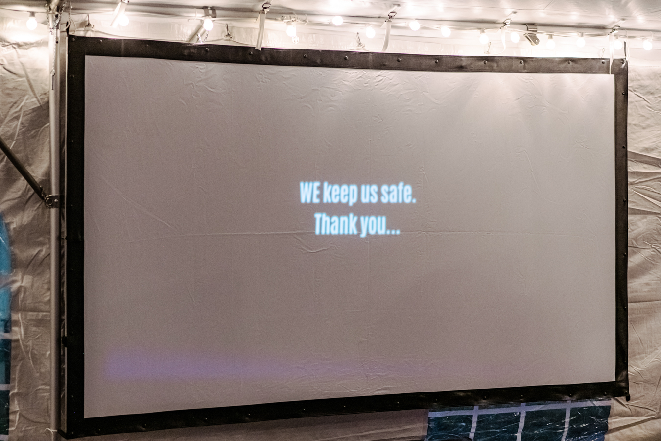 Screen with "We keep us safe" text from the closing of video presentation during SFNC gala