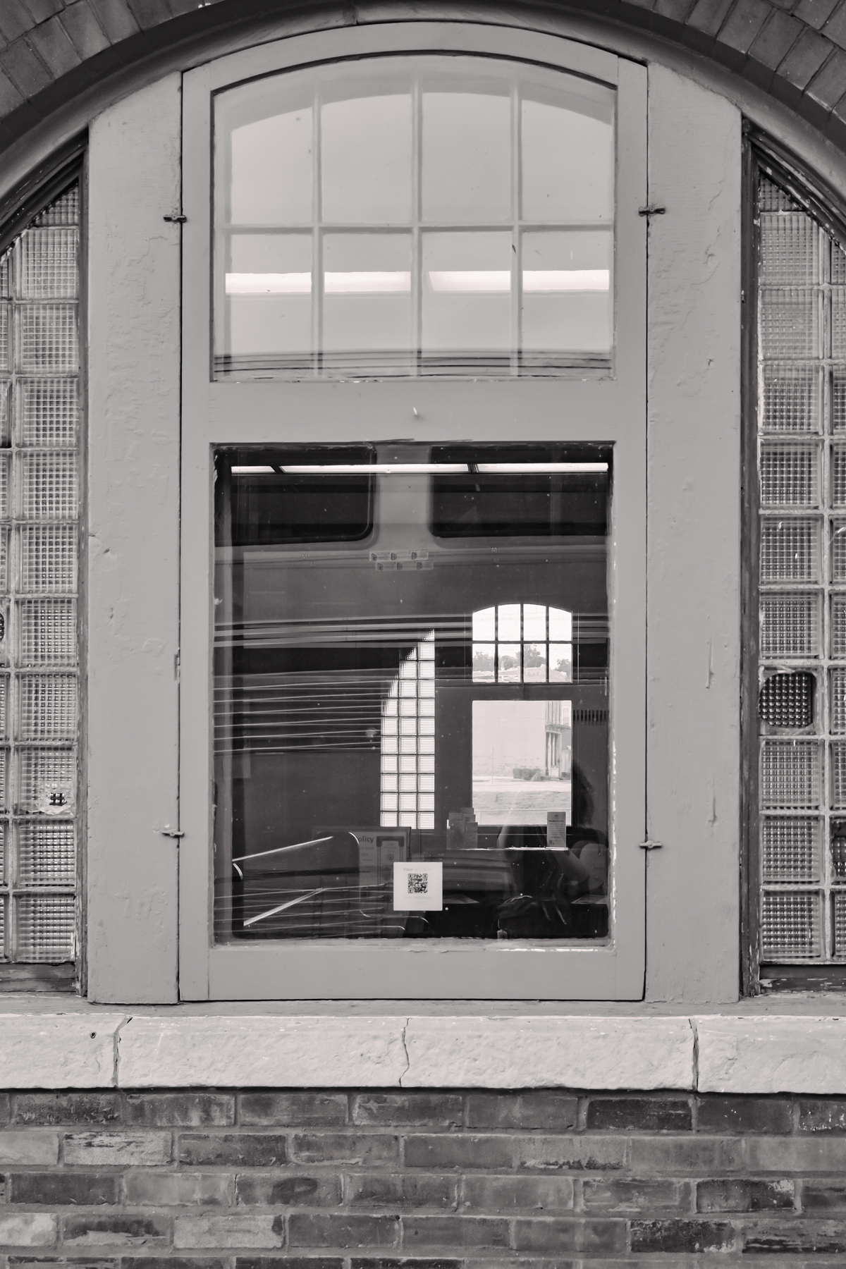 black and white photo through an arched building window