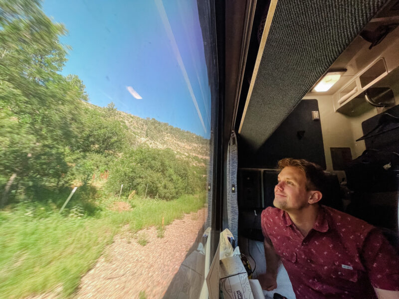 man looking out window of train roommette