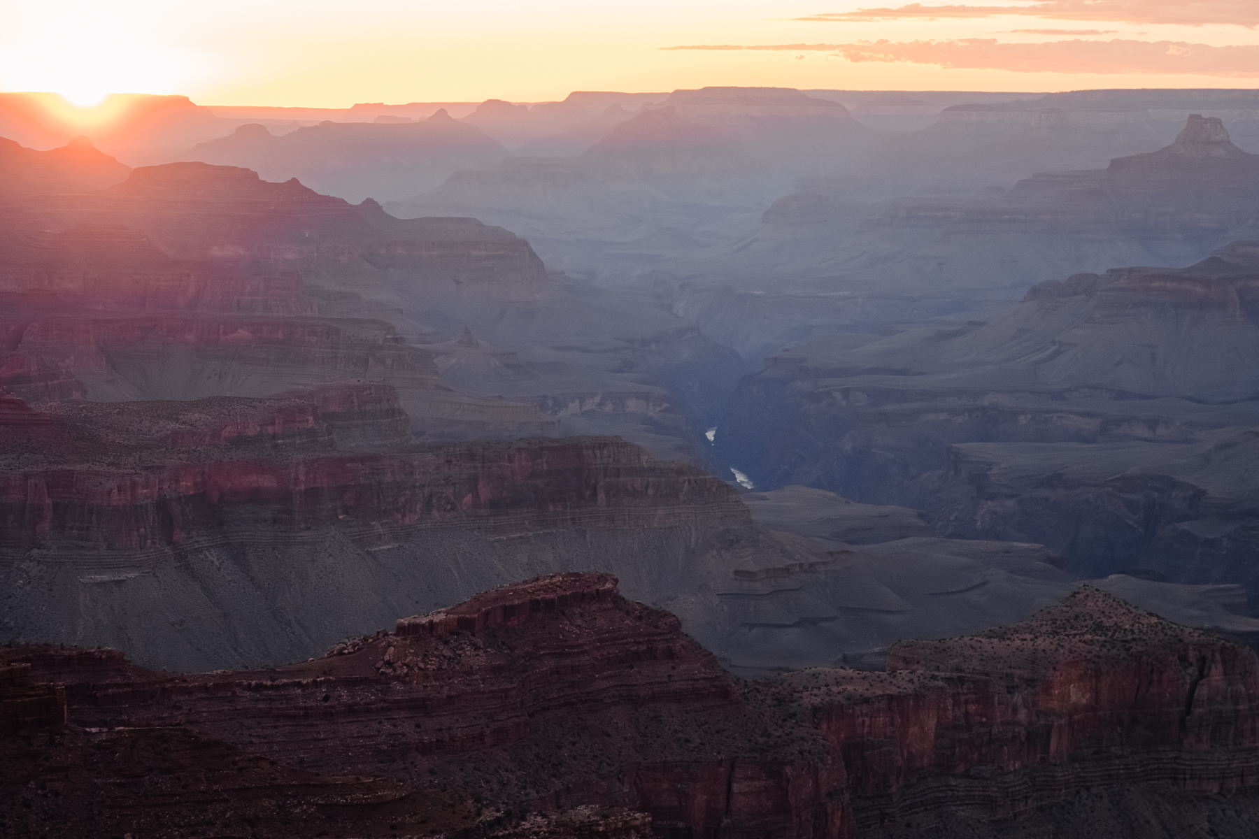 view of grand canyon at dusk with colorado river in distance