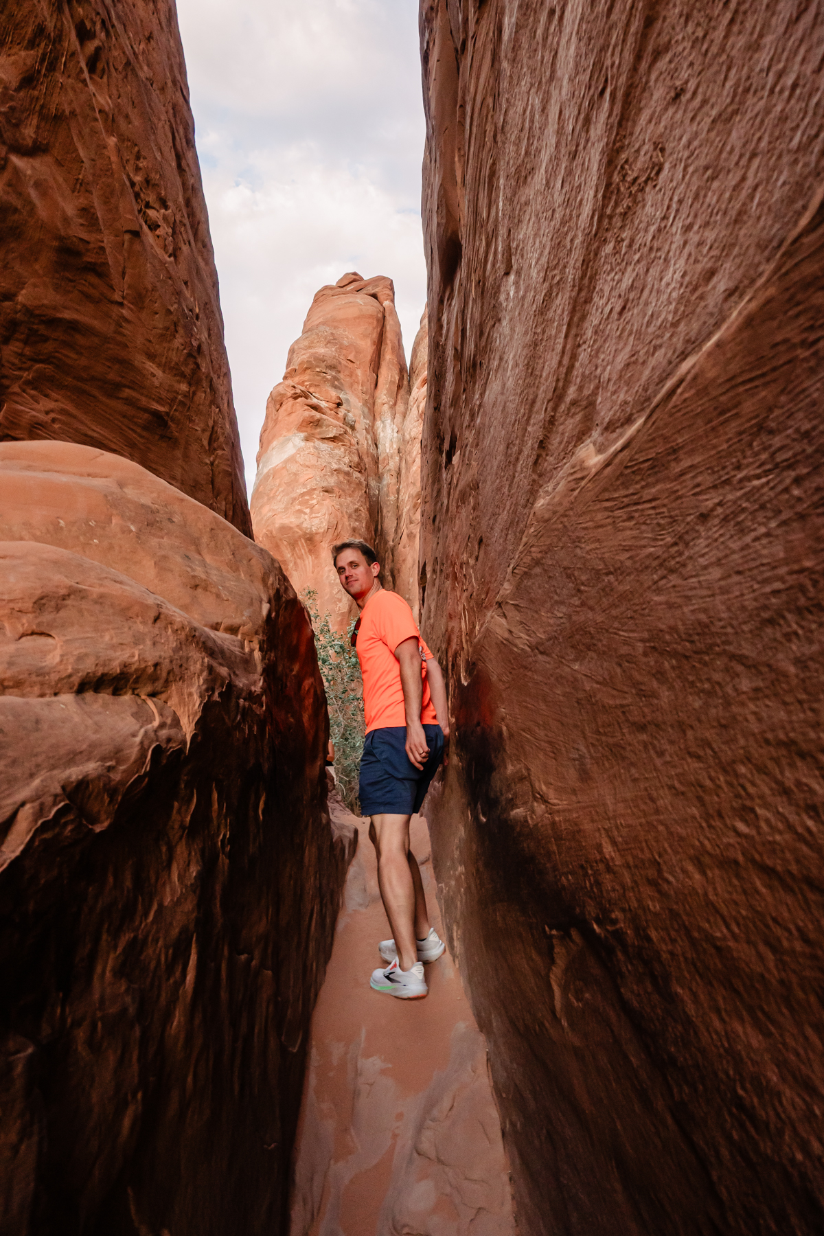 man waking between rocks at arches national park