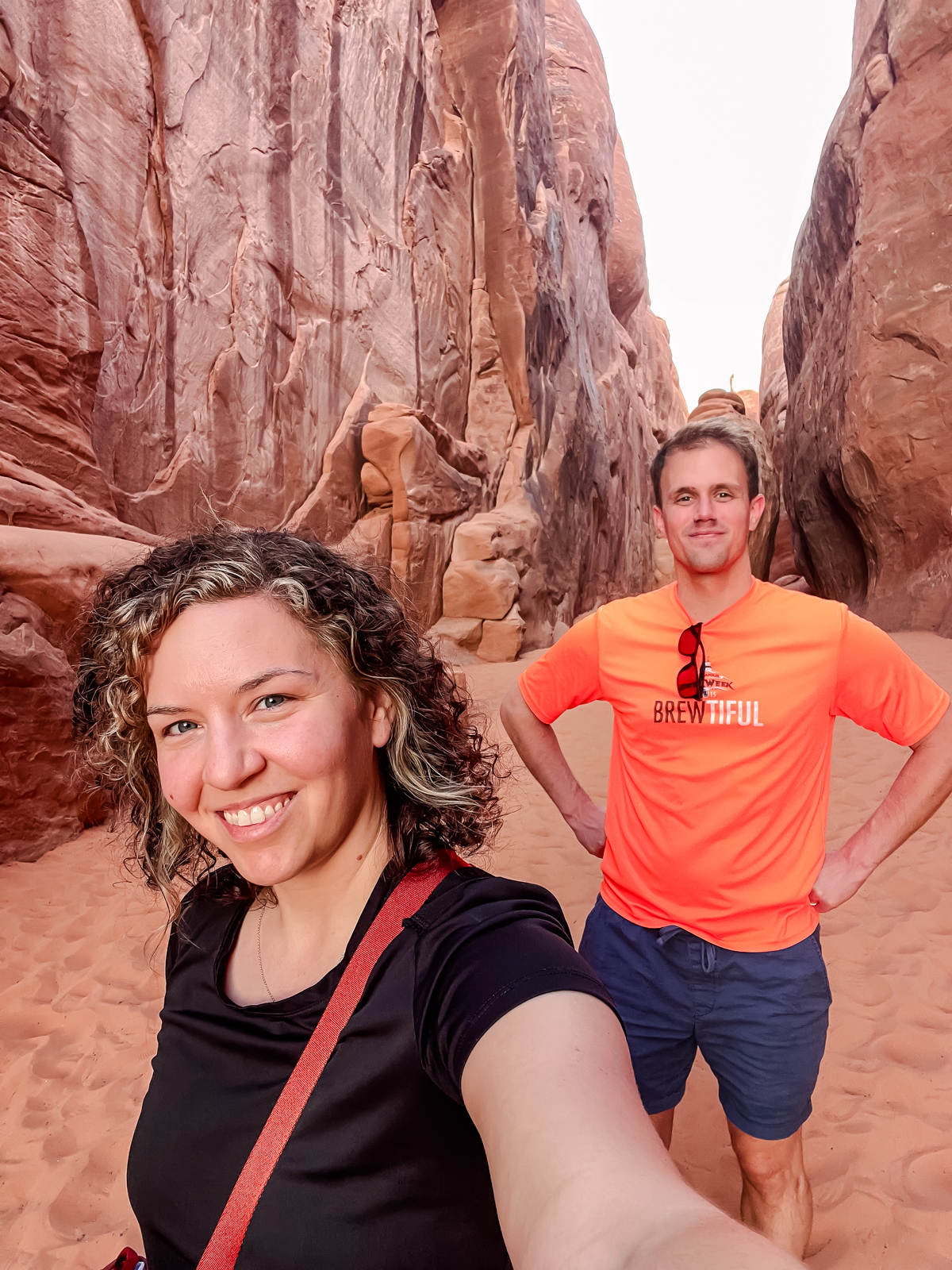 couple between rocks at arches national park
