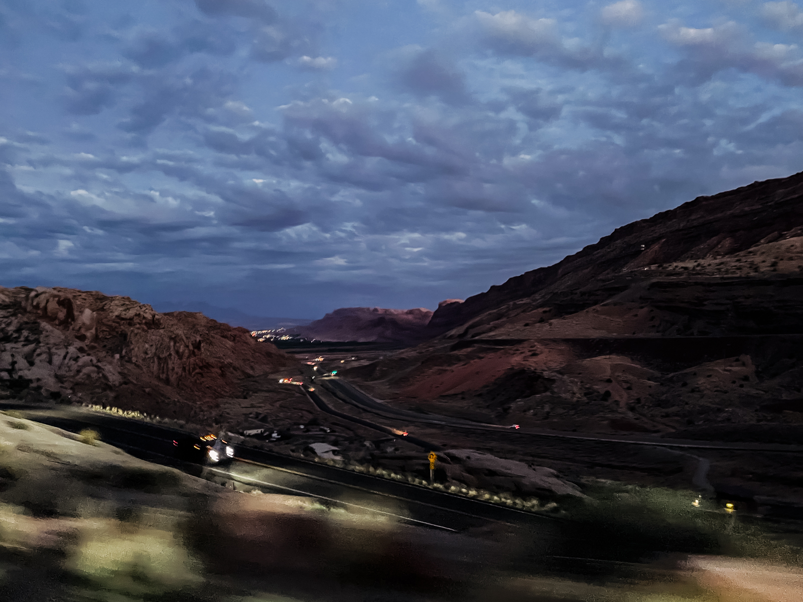 roadway leaving mountainous area of arches national park at night
