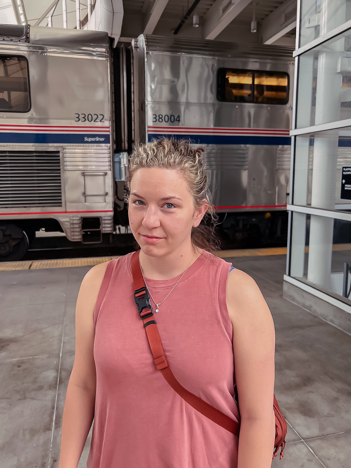 woman smirking with puffy eyes from crying in front of train