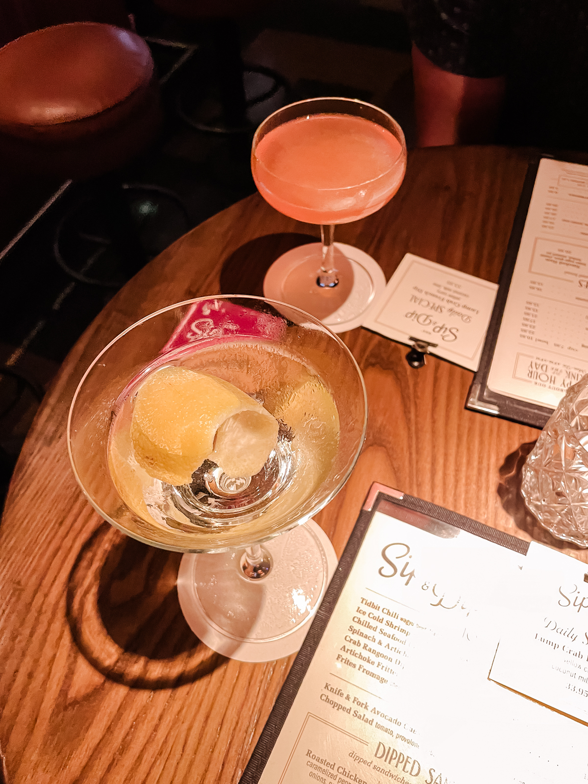 two drinks on a warmly lit table at Gus Sip n Dip