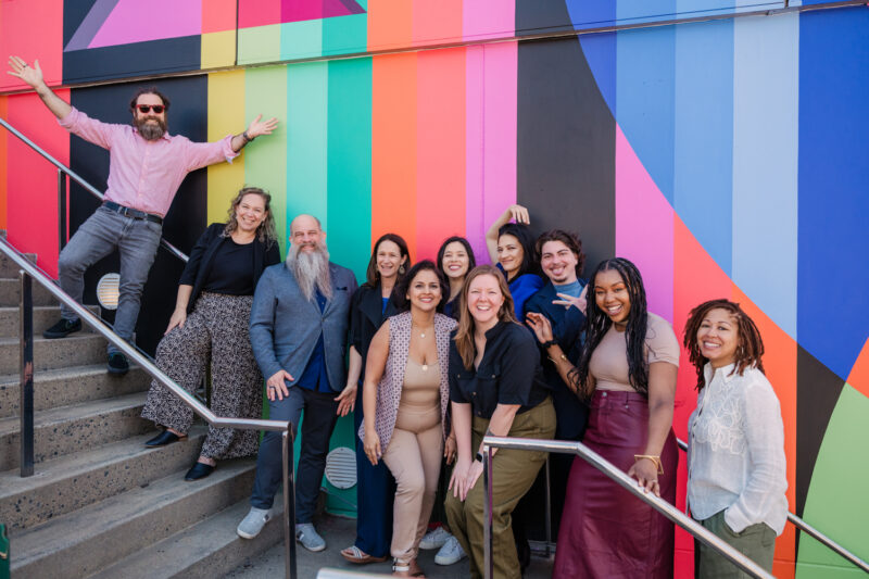 group photo in front of a colorful mural