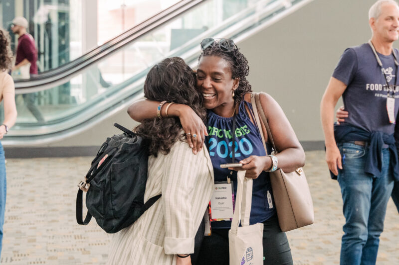 guests hug at refed conference