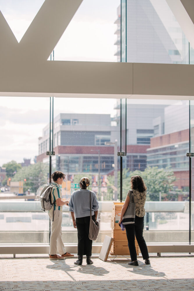 conference guests look out window at baltimore city