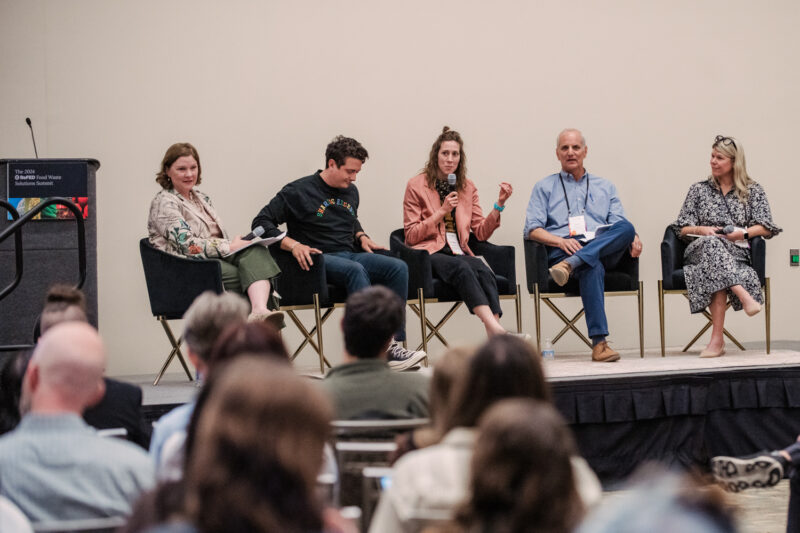 refed conference speakers on a stage for a panel