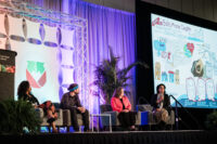 refed conference speakers on a stage for a panel