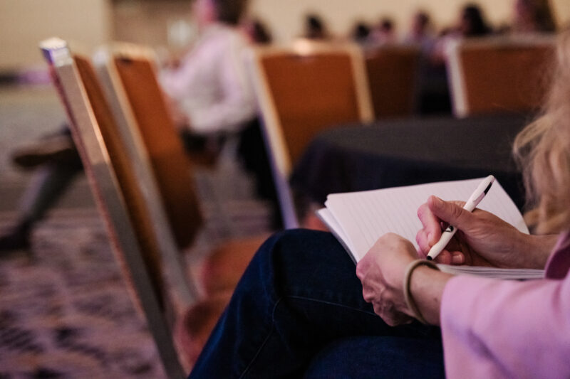 close up of attendee writing in notebook