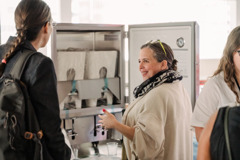 summit sponsor shows a display to attendee